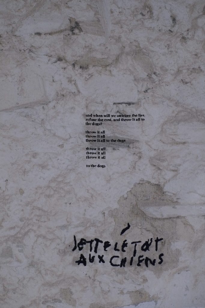 A textured background with faint patterns and a poem printed in dark text, featuring phrases about throwing things to the dogs. The bottom left corner contains the phrase "je te ple tout aux chiens" written in bold black ink.