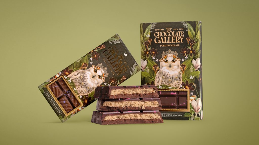 A beautifully designed chocolate packaging from The Chocolate Gallery featuring a whimsical owl illustration, with chocolate bars displayed attractively alongside the box.