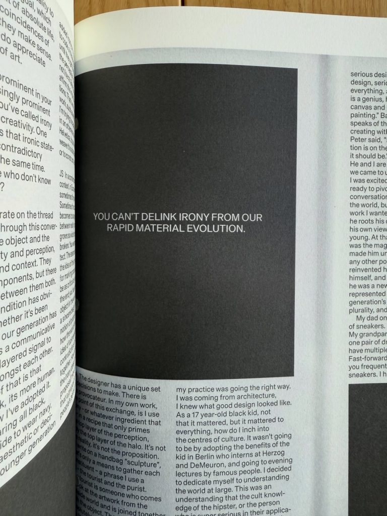 A close-up of an open book page featuring a prominent quote that reads, 'YOU CAN'T DELINK IRONY FROM OUR RAPID MATERIAL EVOLUTION.' The surrounding pages contain small text in a contrasting font.