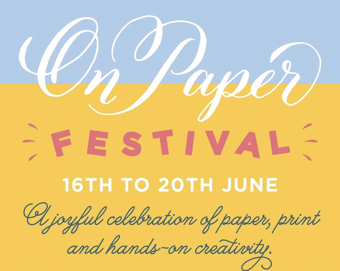 A blue and yellow background with the On Paper Festival and dates written on top in white and pink font.