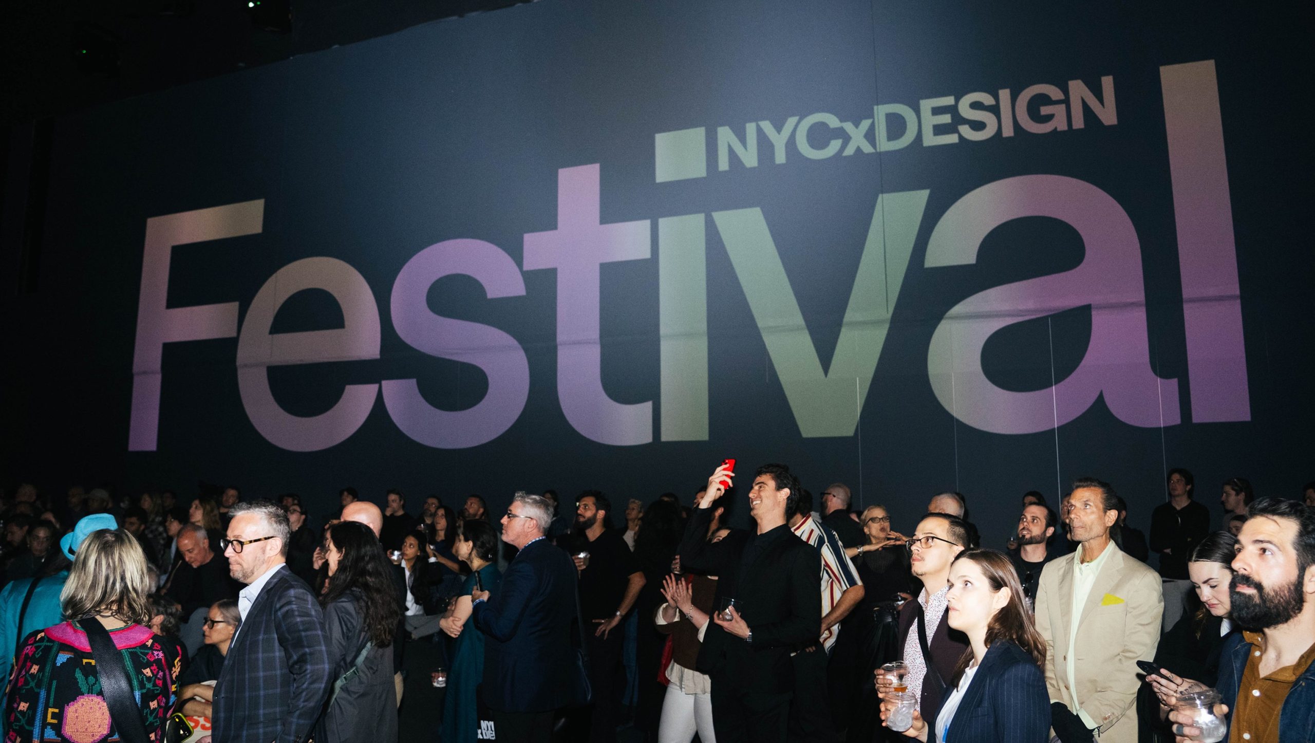 A photo showing a crowd of people in front of a wall displaying 'NYCxDesign Festival' in large font.